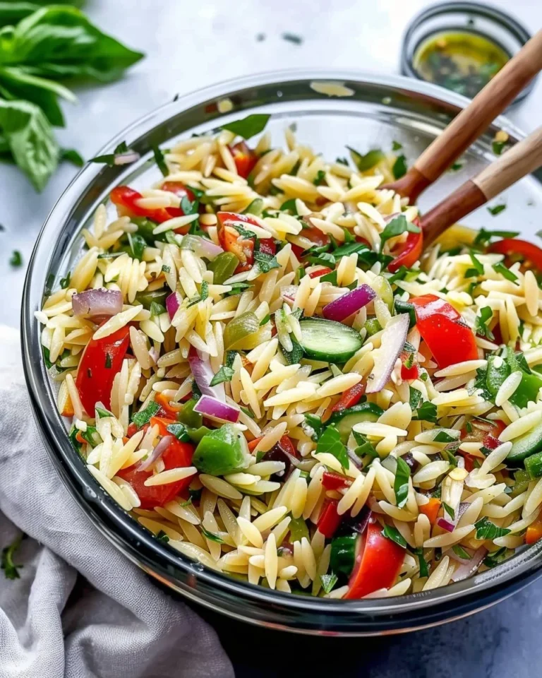 Colorful orzo pasta salad with vegetables and dressing in a bowl